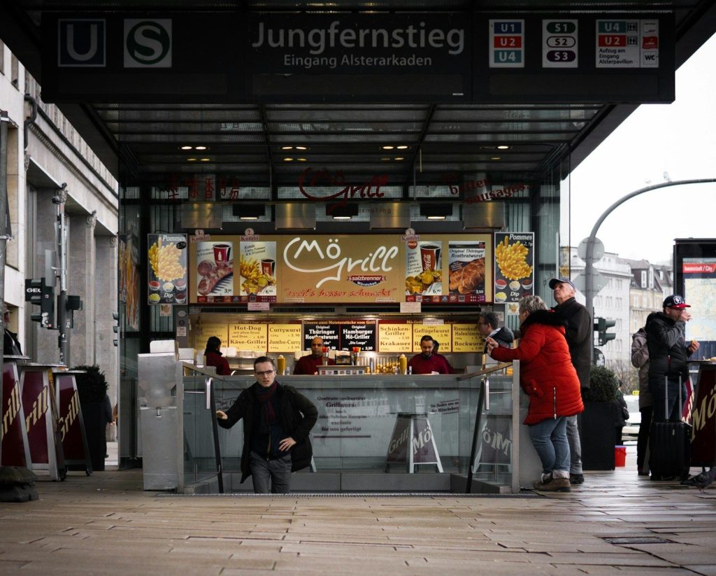 a group of people standing around a food stand